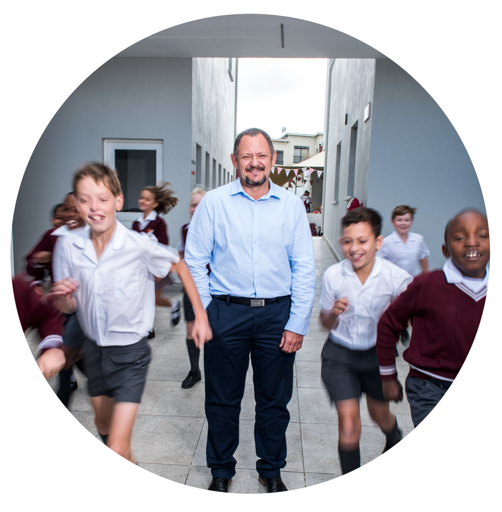 Riverside College learners playing and running past Director Dave Swart in front of the building